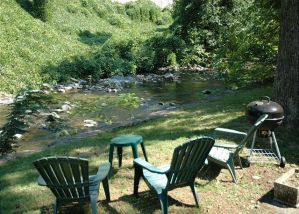 Chairs and a grill beside the river near Bear Cabin in the Smoky Mountains.