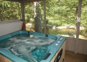 Hot tub on the deck overlooking the river at the Bear Cabin in the Smoky Mountains.