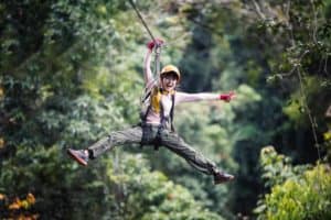 A young woman riding a zipline.