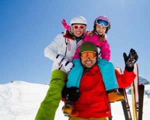Happy family of three on a ski slope.
