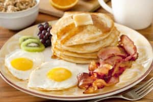 Eggs, bacon, pancakes, and fruit