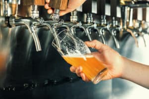 Hand of bartender pouring an IPA on tap