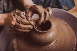person creating pottery on a wheel